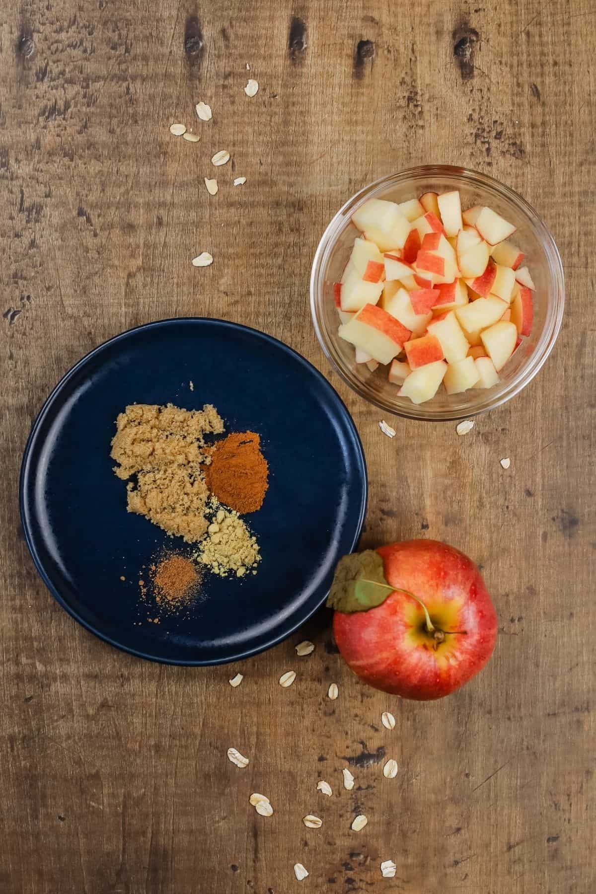 ingredients for apple overnight oats in various glass bowls on the wood table