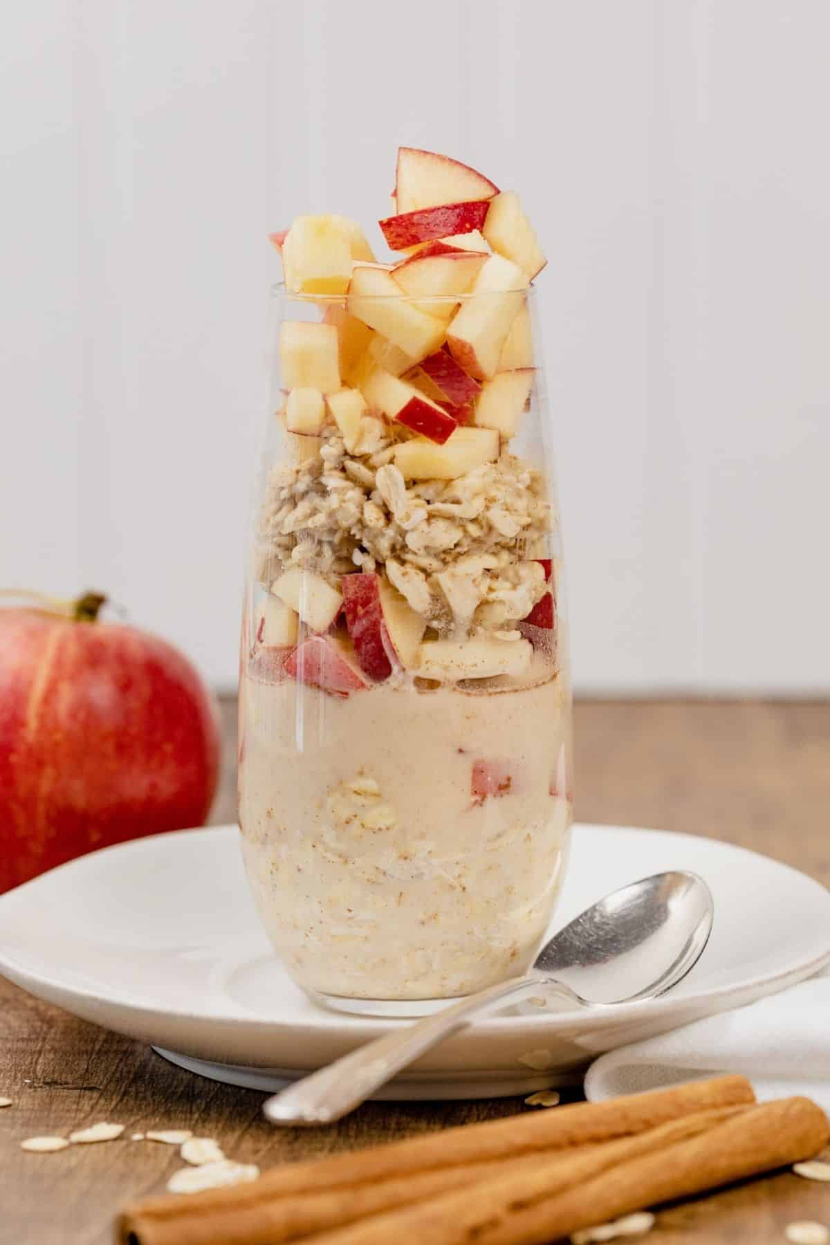 apple cinnamon overnight oats in a tall glass on the table