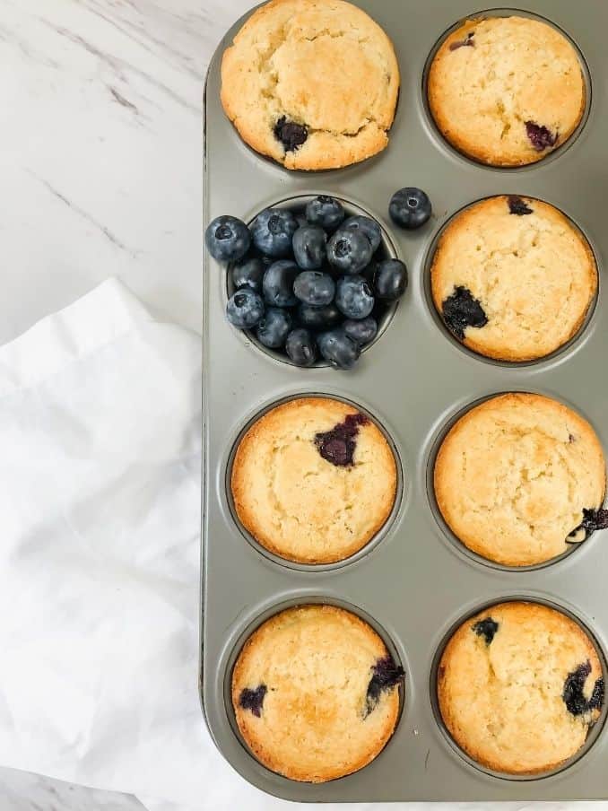 gluten free vegan blueberry muffins in tray with blueberries // livingbeyondallergies.com