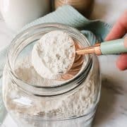 gluten free flour blend recipe with no nightshades or potato flour in a glass jar with a measuring cup
