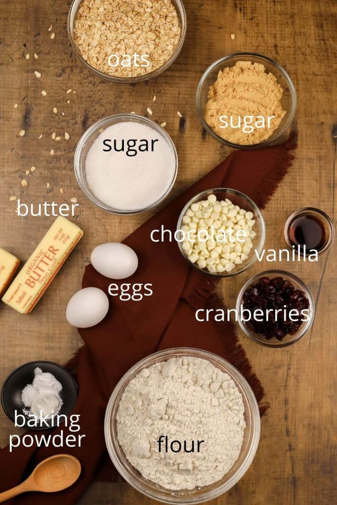 ingredients for cookies in various bowls on a wood table 
