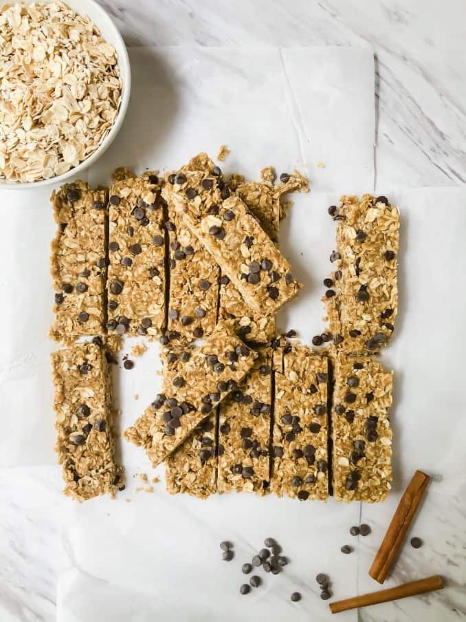 gluten free granola bars on parchment paper surrounded by oats and cinnamon // livingbeyondallergies.com