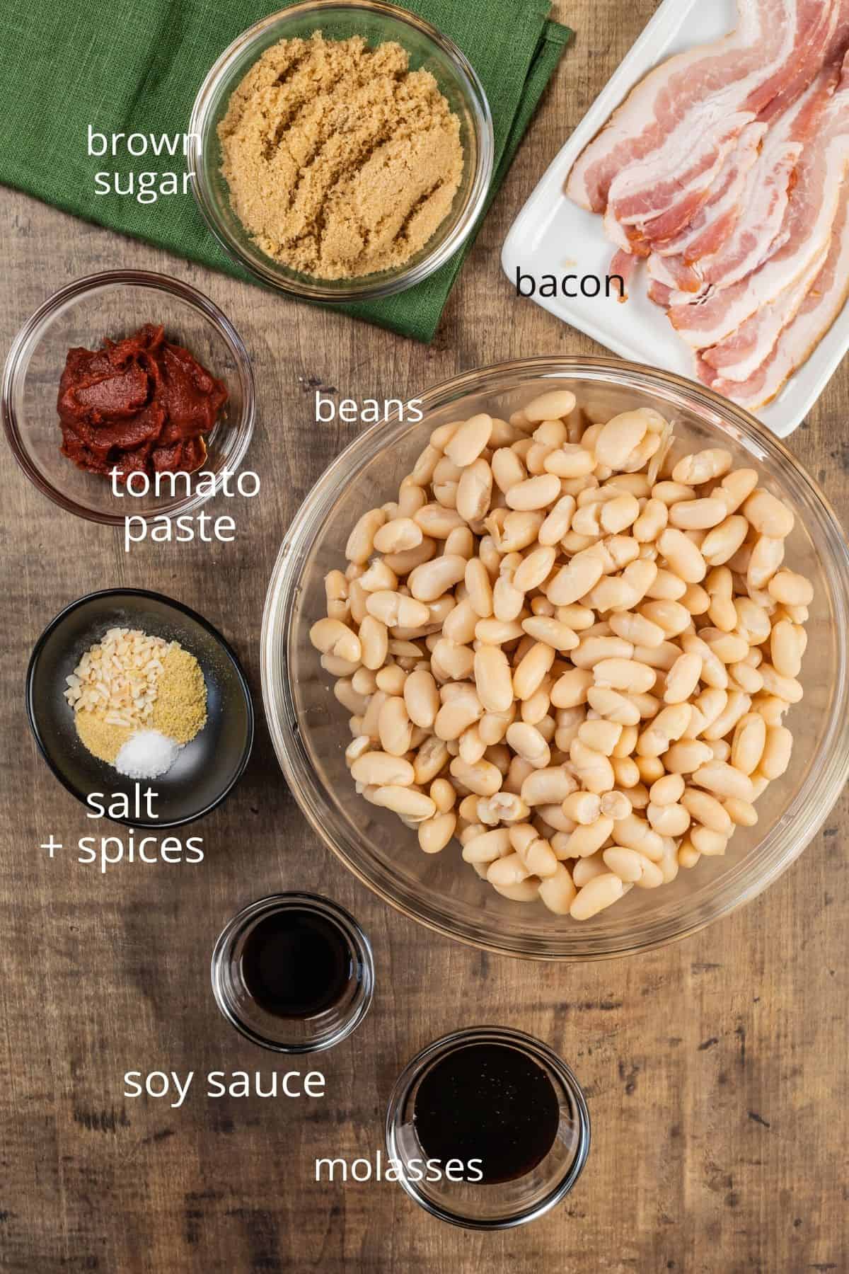 ingredients for baked beans in various glass bowls on the wood table 