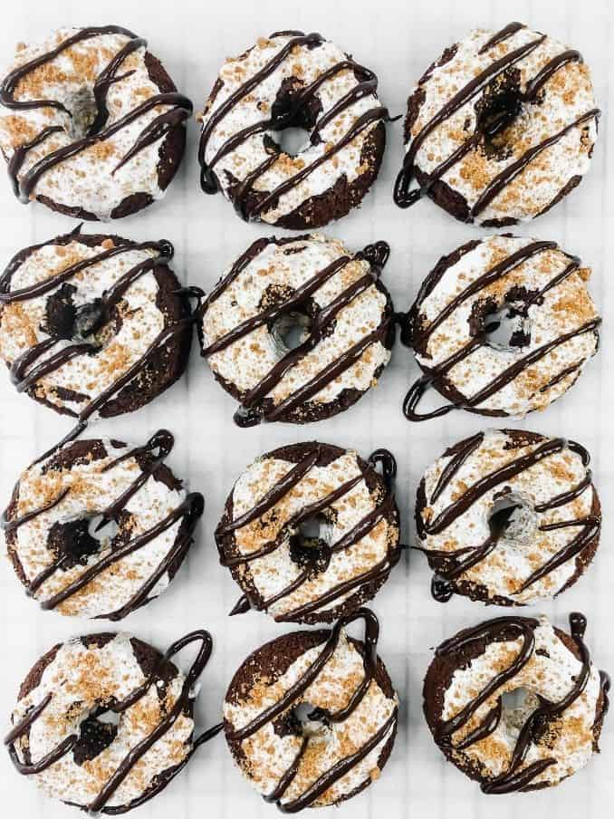 dozen smores donuts on a white table lined up