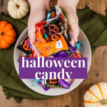 hands holding allergy free halloween candy in front of a bowl of the same halloween candy