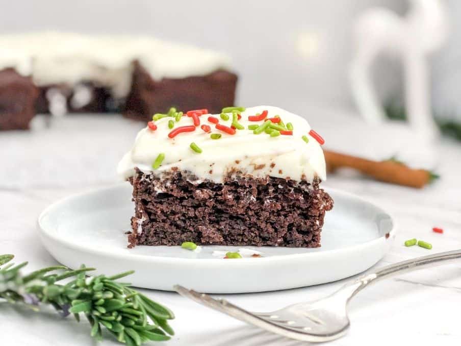 slice of gingerbread cake on white plate with fork on the countertop