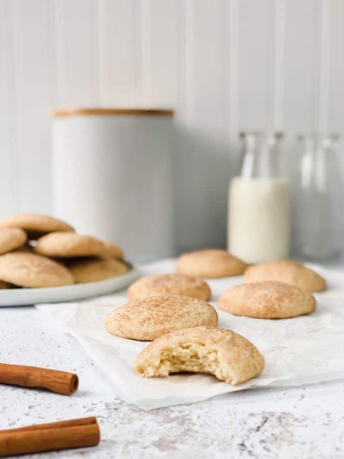 lots of gluten free snickerdoodle cookies resting on the kitchen countertop and a white plate with milk in a jar // livingbeyondallergies.com