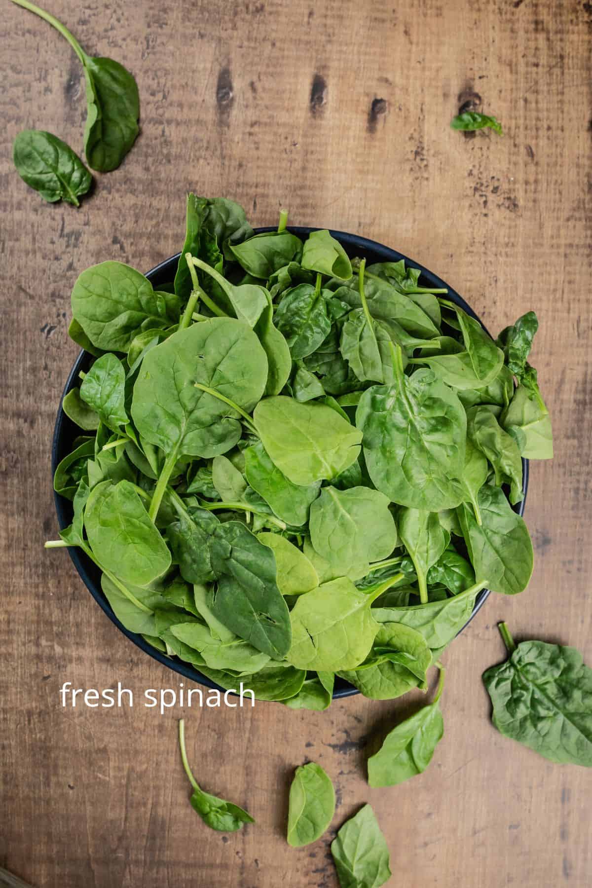 a big bowl filled with fresh spinach leaves