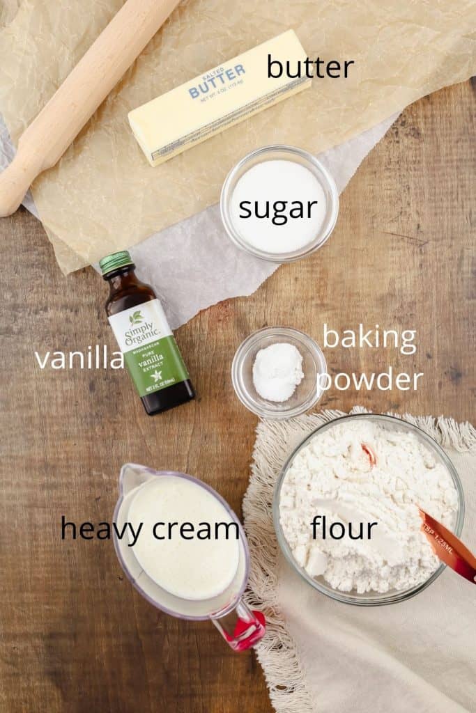 ingredients for vanilla scones on a wood tabletop in various glass bowls 