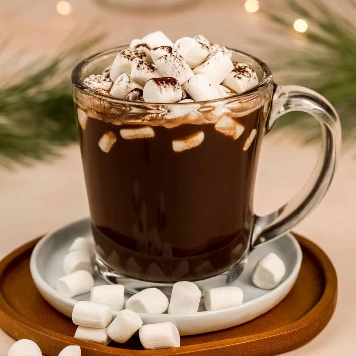 dairy free hot chocolate in a glass mug with many marshmallows on top