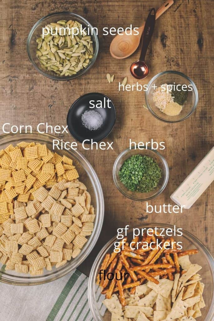 ingredients for Chex mix in various glass bowls on the wood table top