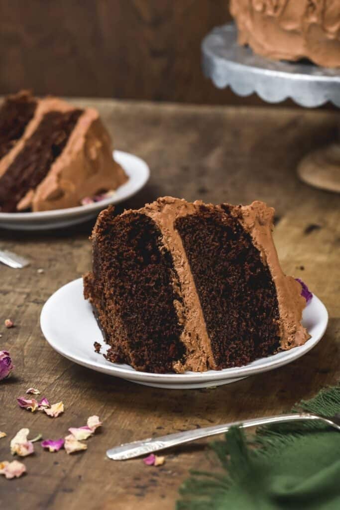 slices of vegan chocolate cake on plates on a wood table
