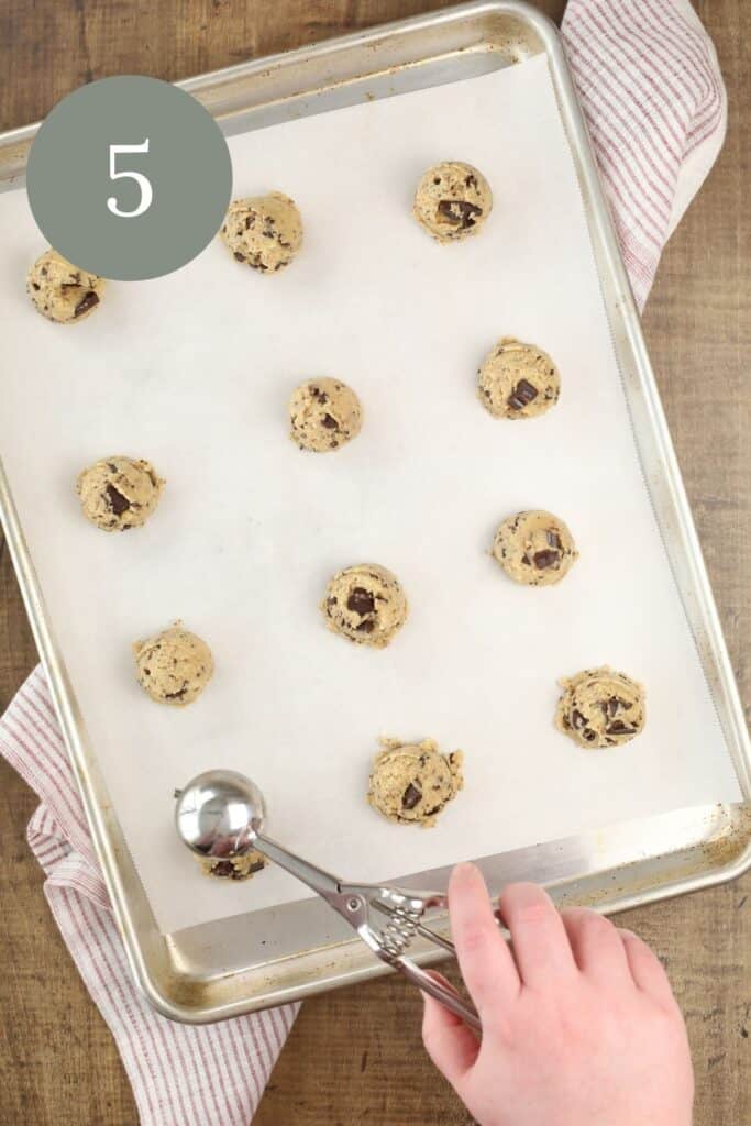 using a cookie scoop to portion the cookie dough onto a tray