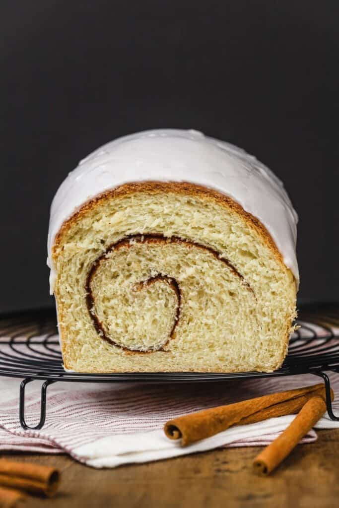 dairy free cinnamon bread sliced open to see the swirl on a wire rack