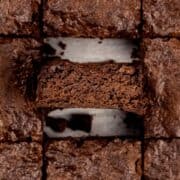 egg free brownies in pan with a middle brownie on it's side to see the thick and chewy insides