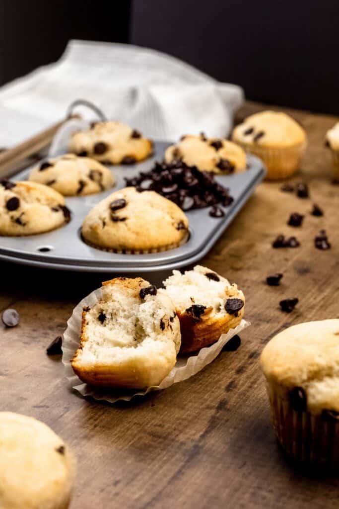 chocolate chip muffin halves to show the inside of the fluffy muffin surrounded by more muffins and chocolate chips 