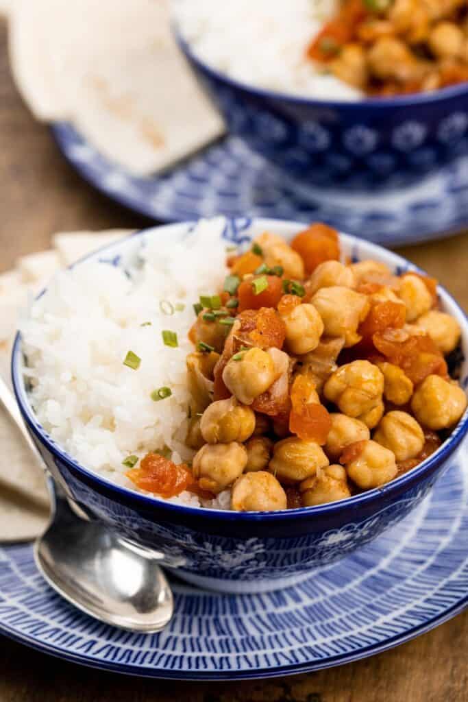 close up of blue bowl filled half with Chana Masala and half with rice