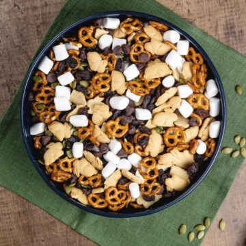 up close view of s'mores trail mix in a blue bowl on a wood table