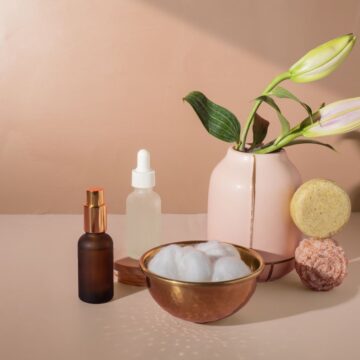 different bath and body care products on a pink table and background
