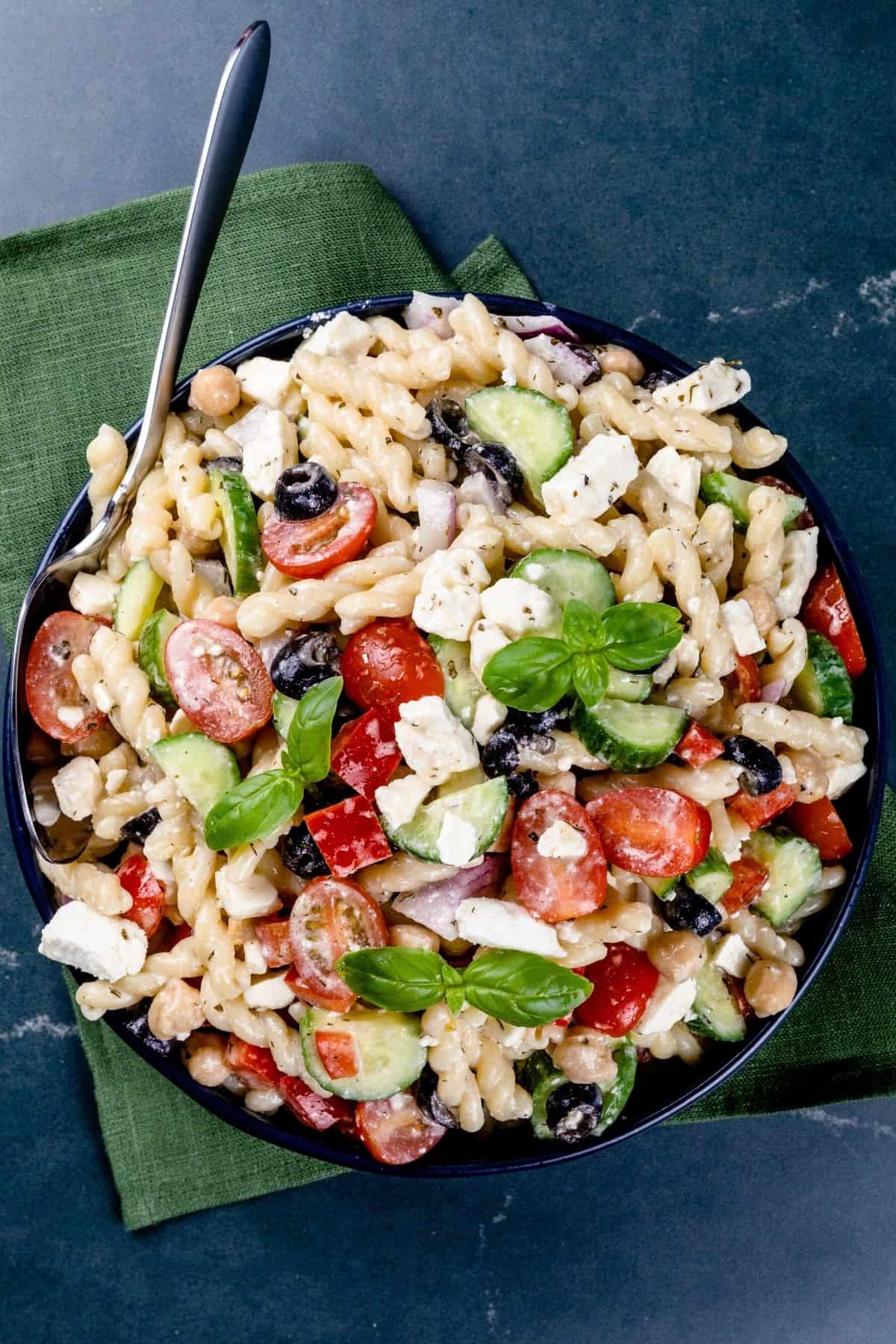 finished gluten free greek pasta salad in a big bowl on dark marble countertop