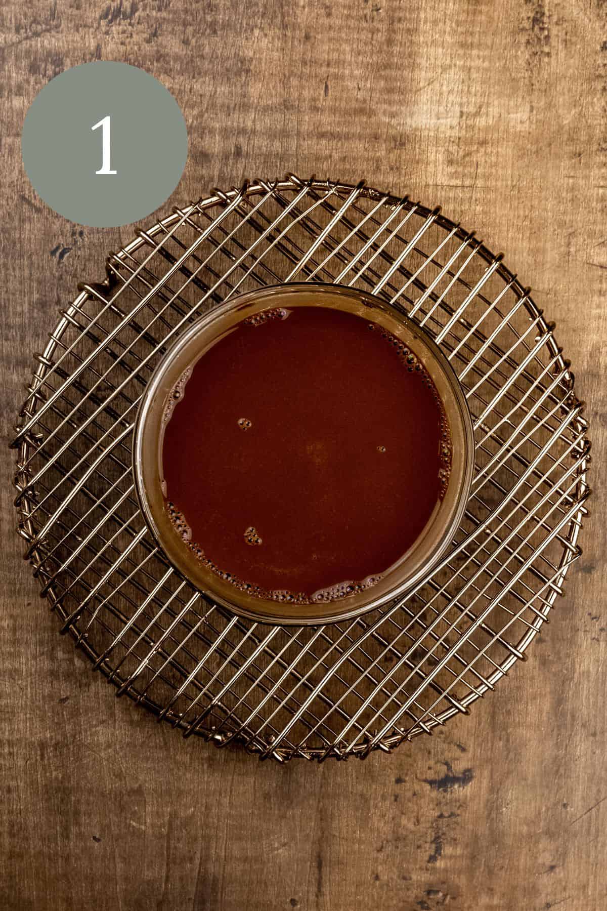 bowl of blooming cocoa powder on a wire cooling rack on a wood table