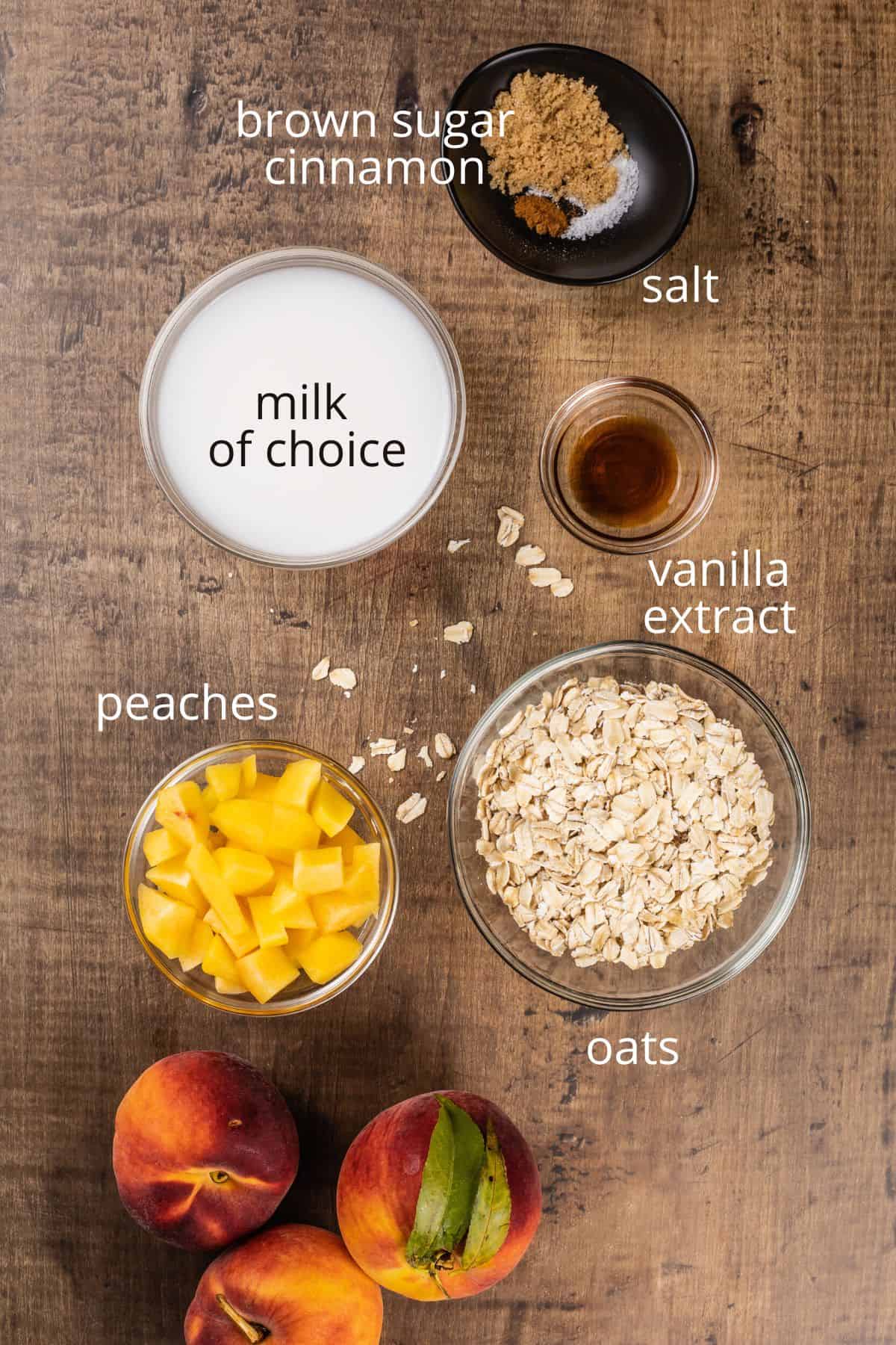 ingredients for peach overnight oats in various glass bowls on the wood tabletop