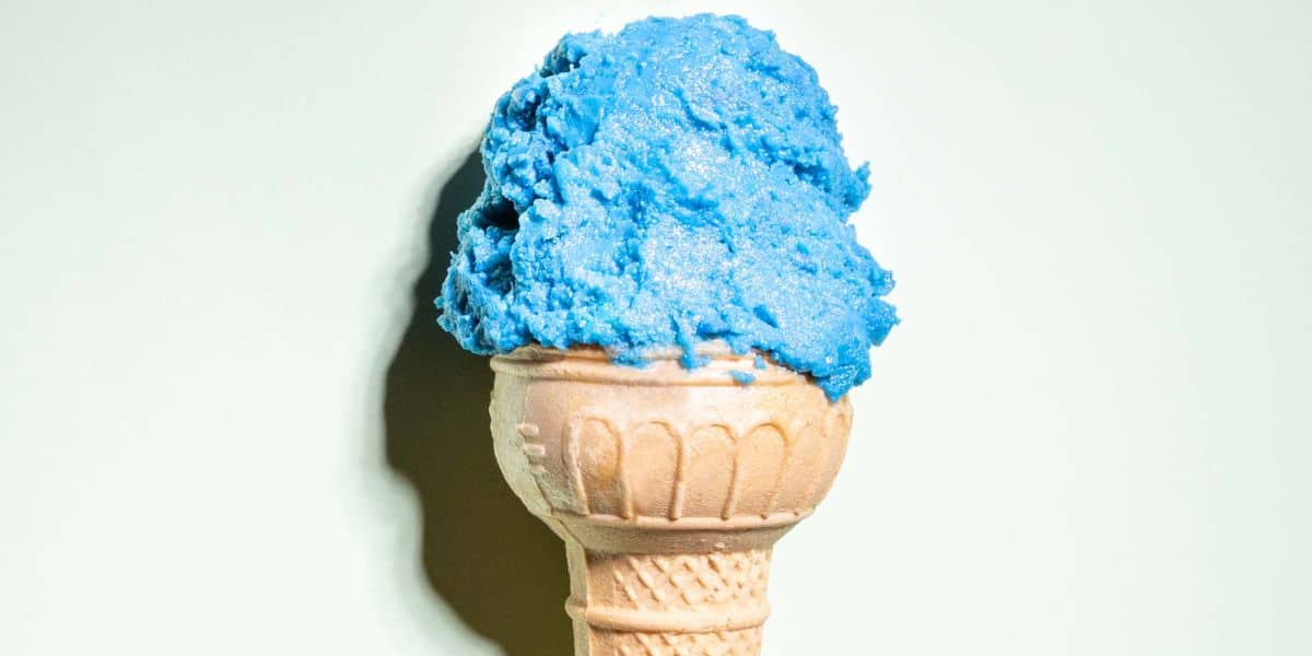 Close up of a blue ice cream scoop on a cone.